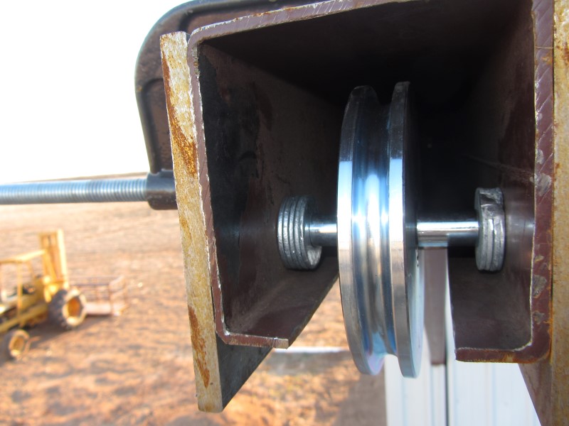 Close-up view of installing single sheave custom cable pulley block for airplane hangar