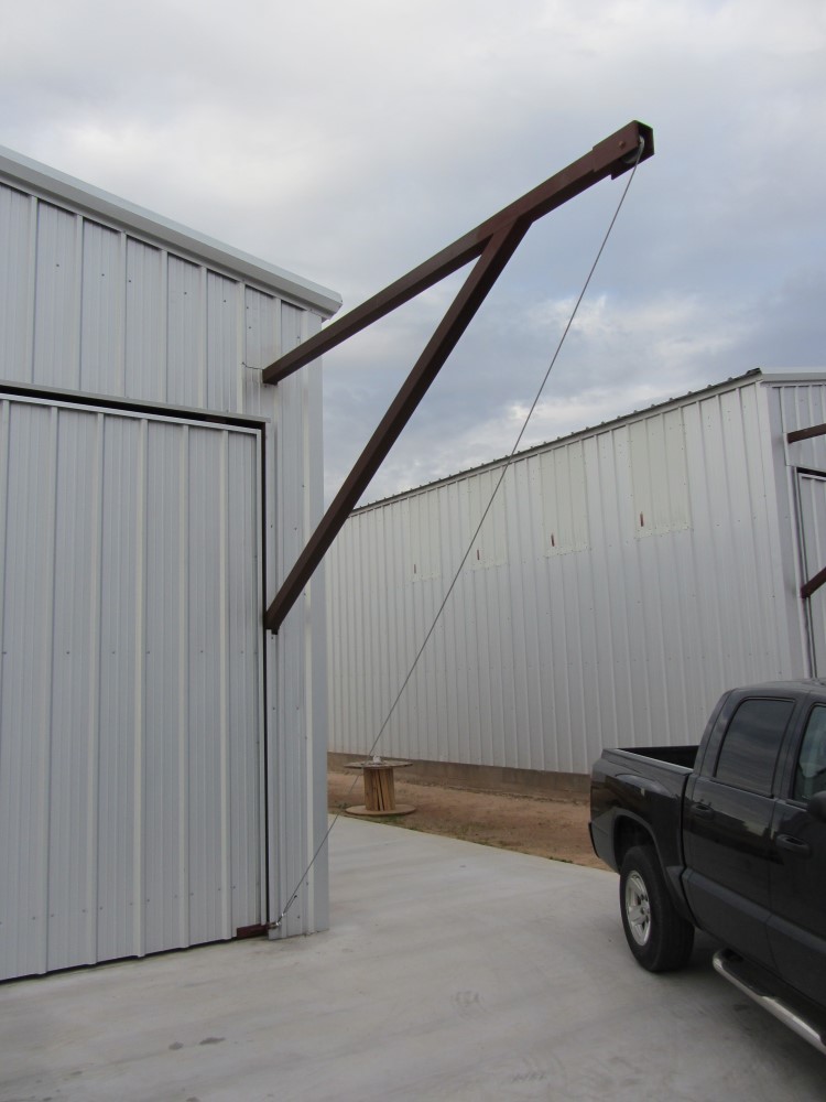 Exterior of hanger depicts use of pulley block system to raise & lower large overhead door